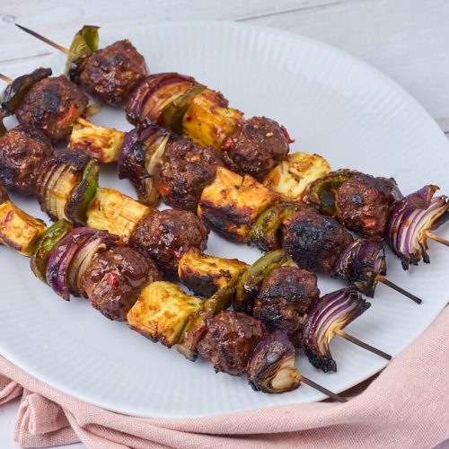 grillspyd med kødboller, grillost og rødløg penslet med barbecuesauce.