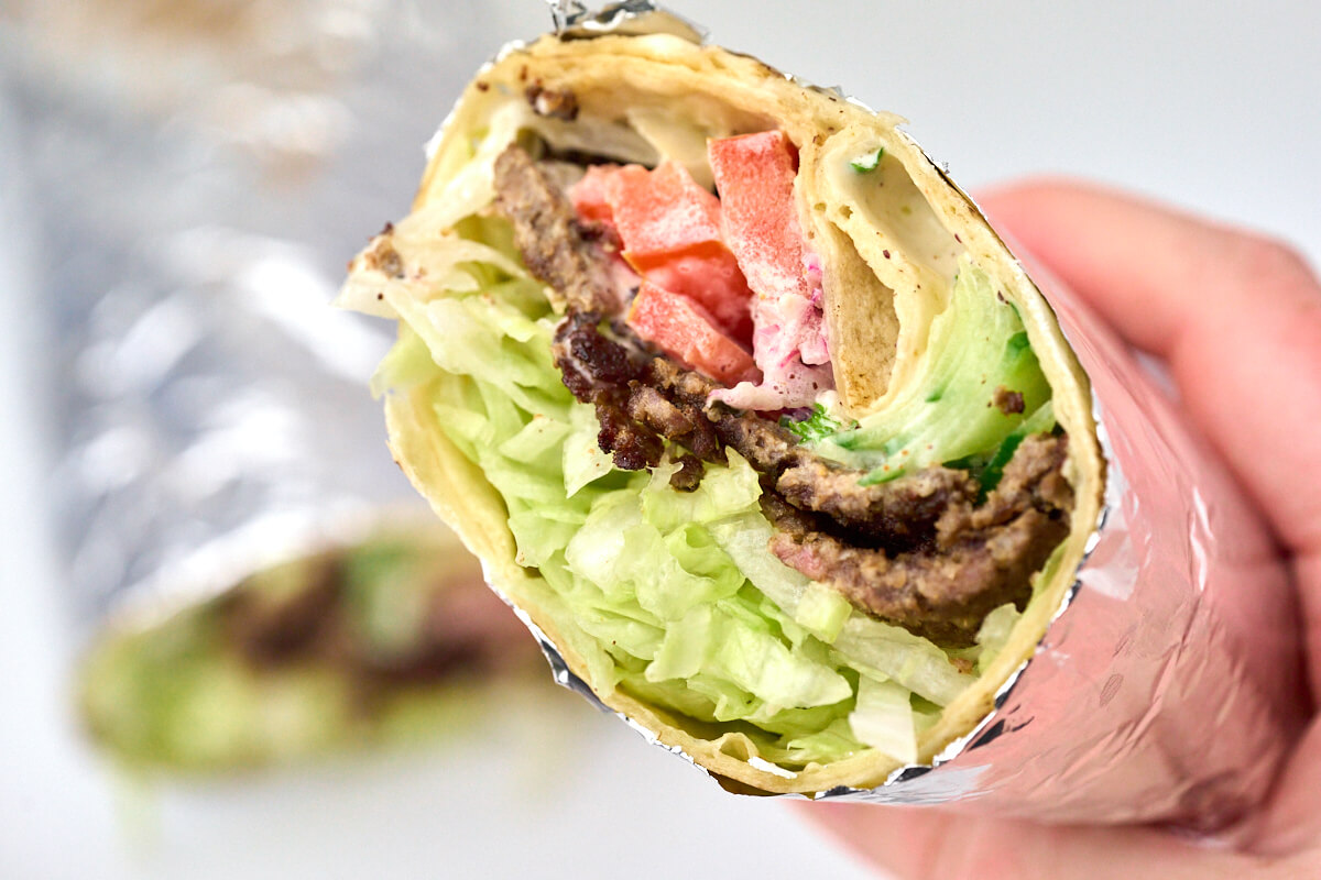 hjemmelavet döner kebab i rullekebab med salat, grønt og kebabdressing.