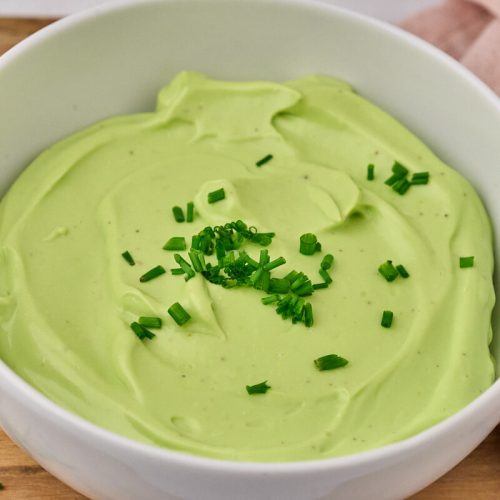 Hjemmelavet purløgsmayonnaise i skål med frisk purløg på toppen.