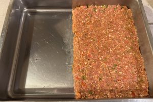 kødet der er lagt i bradepanden.