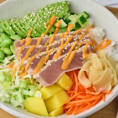 Poke bowl med lynstegt tun, sushiris og forskellige grøntsager.