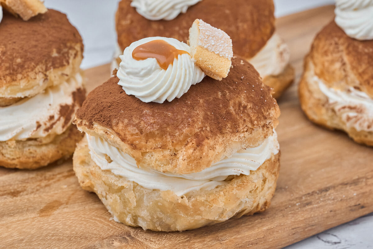 tiramisu fastelavnsboller med mascarponecreme og kaffekaramel og ladyfingers samt kakao pรฅ toppen.