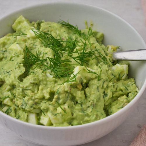 æggesalat med avocado og dild i skål.