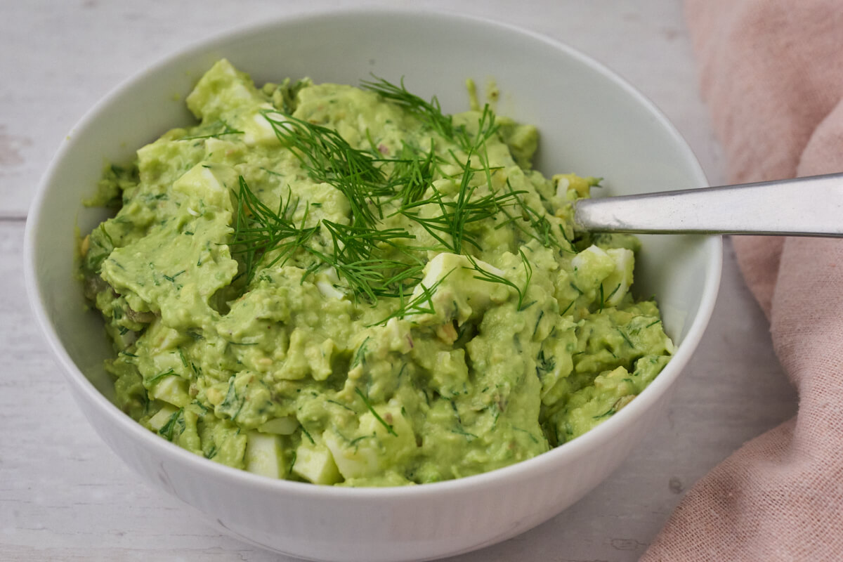 æggesalat med avocado og dild i skål.