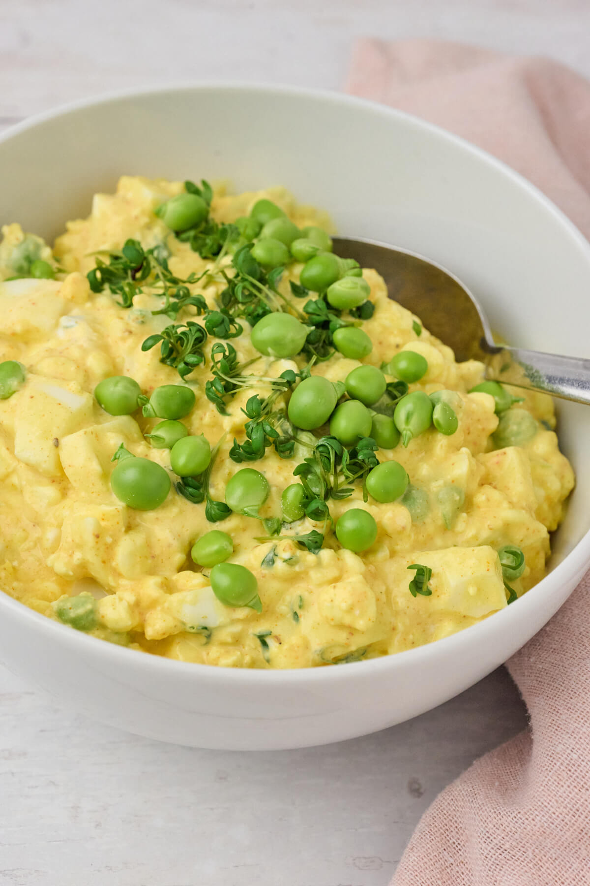 skål med hjemmelavet æggesalat med hytteost, ærter og karse.