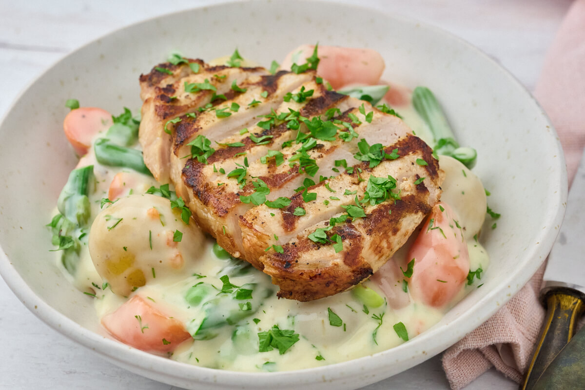Forårsfrikassé med kartofler og grøntsager med grillet svinekotelet.