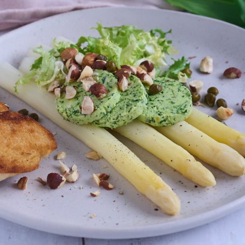 hvide asparges med ramsløgssmør og ristede hasselnødder samt kapers, salat og brød.