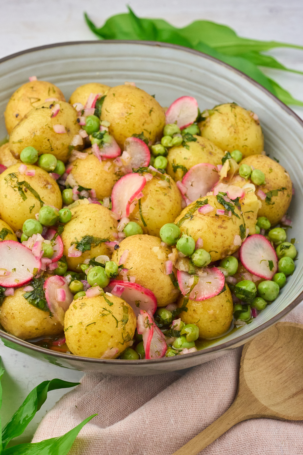marineret kartoffelsalat med ramsløg, ærter og radiser.
