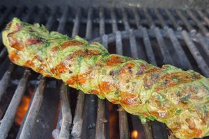 marineret svinemørbrad der ligger på grillen.