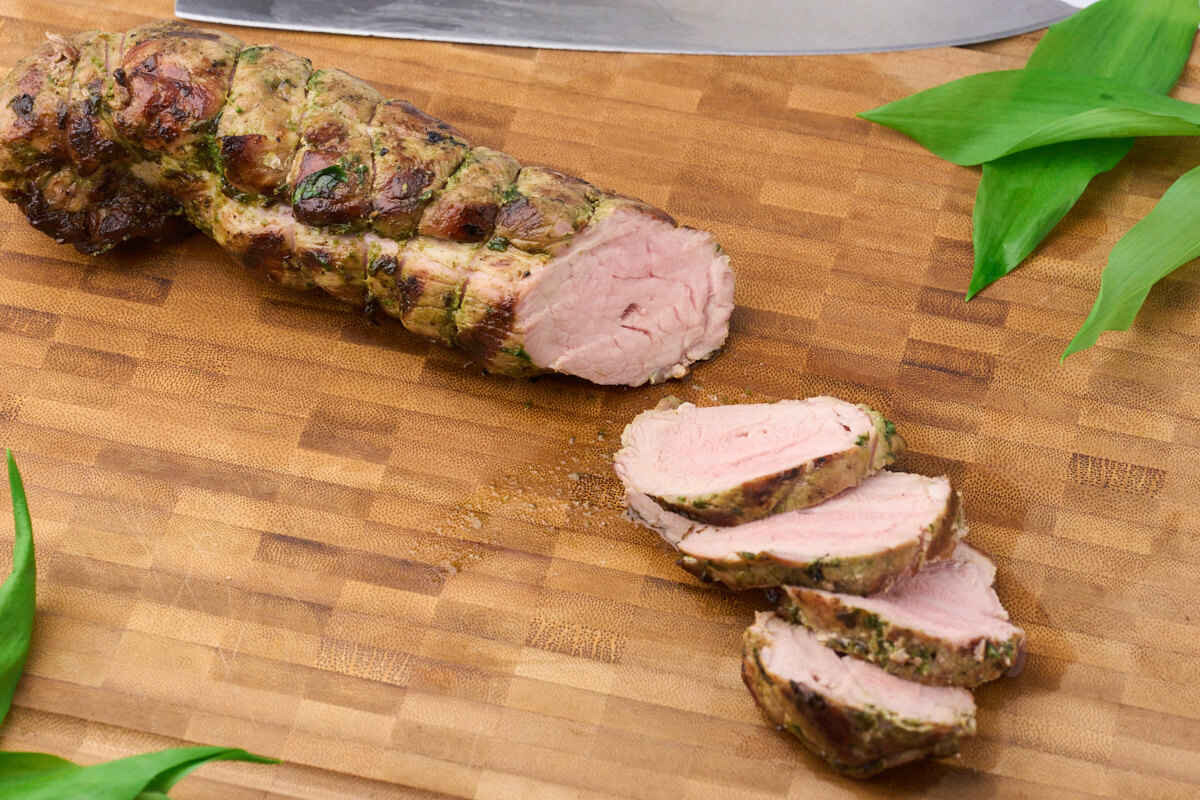 ramsløgsmarineret svinemørbrad på grill skåret i skiver og klar til servering.