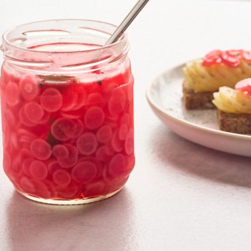 syltede radiser i glas med kartoffelmadder ved siden af.