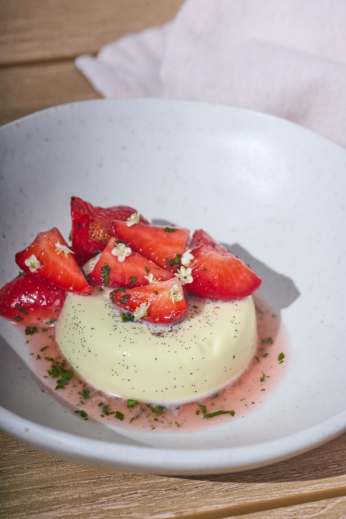 hyldeblomst-panna cotta med jordbær, mynte og hyldeblomster.