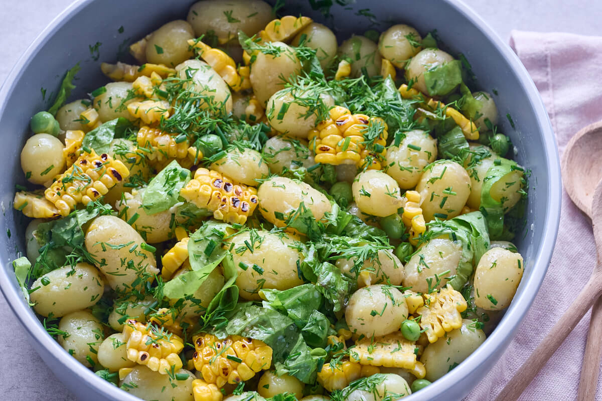 kartoffelsalat med nye kartofler og grillede majs samt ærter, dild og purløg.