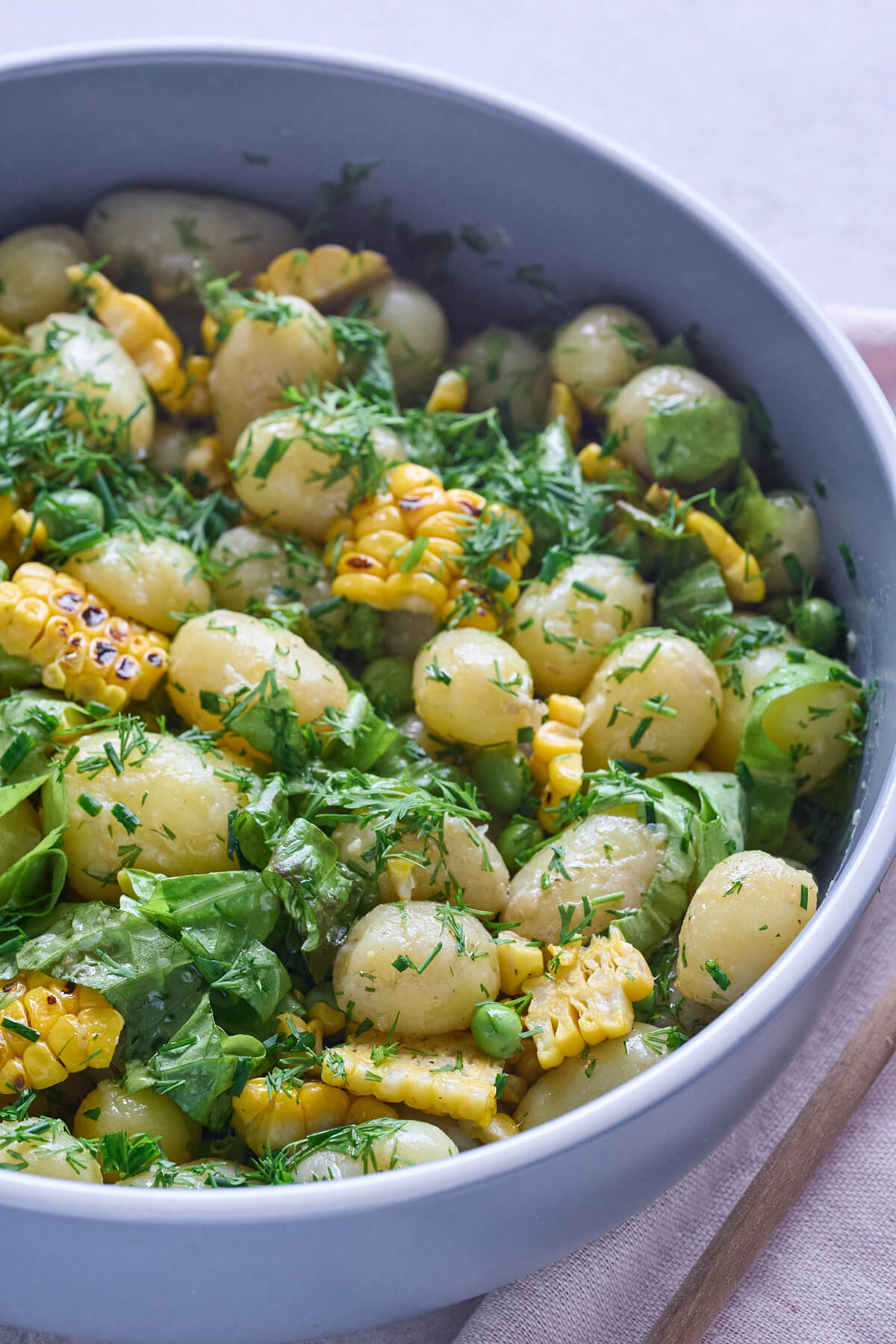 hjemmelavet kartoffelsalat med nye kartofler fra haven, ærter, grillede majs og masser af friske urter.