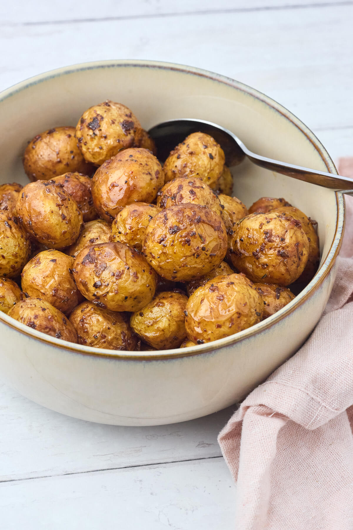 skål med små kartofler i airfryer lavet med hvidløg og krydderurter.